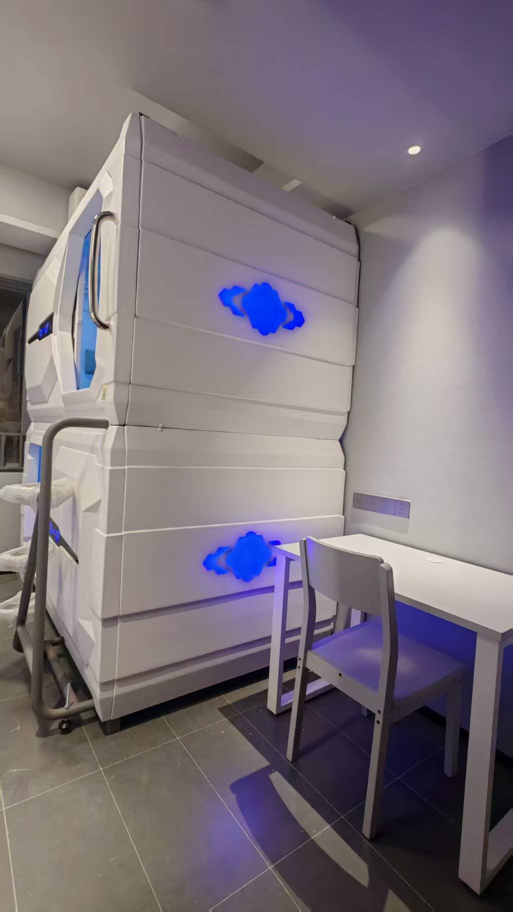 Capsule pods beside a desk in the source-backed Nansha employee rest room display